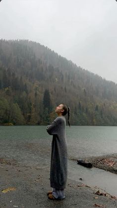 a woman standing in front of a body of water