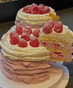 three layered cakes with raspberries on top