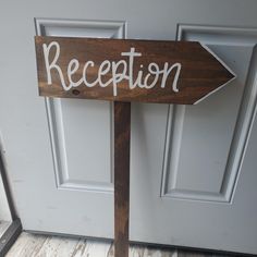 a wooden sign that says reception on the side of a white door with wood frame