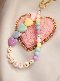 a pink heart shaped keychain with beads on it