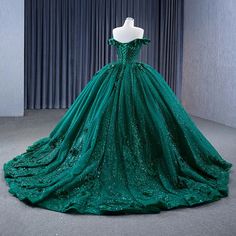 Embody elegance and sophistication in this dark green ball gown, perfect for a quinceañera or evening celebration. This dress is crafted from luxurious tulle, this dress has a stunning off-the-shoulder neckline that gracefully frames the shoulders and adds a hint of timeless romance. The voluminous ball-gown silhouette flows beautifully into a chapel-length train, giving you a majestic presence as you make your entrance. The intricate appliques and sparkling beadwork adorn the bodice and cascade Dark Green Ball Gown, 2023 Ball Gown, Green Evening Dresses, Sleeveless Ball Gown, Prom Formal Dresses, Green Ball Gown, Floor Material, Prom Dresses 2023, Mermaid Prom Dresses Lace