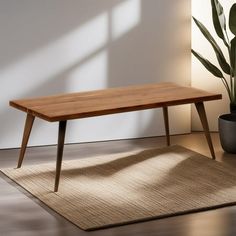 a wooden table sitting on top of a rug next to a potted plant