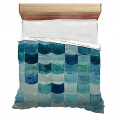 an ocean themed pillow with blue and white waves on the front, along with a wooden headboard