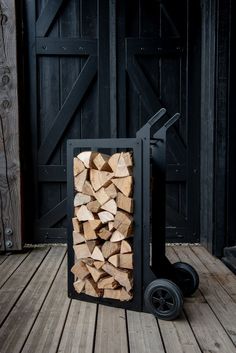 a pile of wood sitting on top of a wooden floor next to a black door