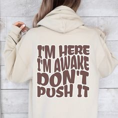 I'm Here I'm Awake Don't Push It Hoodie, Hoodie with Words On Back, Aesthetic Hoodie,Trendy hoodie, hoodies for women, funny hoodie  ♥ WHY YOU WILL LOVE YOUR HOODIES ♥ * Unique cute gift for everyone that is incredibly easy and stress-free to order & receive * Design is a the words Golden mama writing with trendy retro color and font. * Softest quality 50% cotton, 50% polyester with loose fit that runs true to size (unisex) * Extreme comfort with no bulky side seams for great shape and fit that lasts * Collar is ribbed knit, so it retains its shape even after washing * Our unique designs are professionally permanently printed with Direct to Garment printing which feels smooth and flexible :: Printed with Eco-Friendly Inks :: Printed and Shipped from the USA :: Double-Needle Stitching Throu Funny Hooded Hoodie For Streetwear, Funny Hooded Sweatshirt With Letter Print, Funny Cotton Hoodie For Winter, Funny Long Sleeve Hoodie For Streetwear, Funny Graphic Print Hoodie For Winter, Funny Hooded Sweatshirt For Winter, Funny Graphic Print Winter Hoodie, Funny Winter Hoodie With Graphic Print, Winter Funny Graphic Print Hoodie