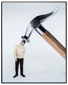 a man standing in front of a giant hammer