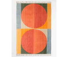 an orange and green rug with two circles on the front, one in red and one in blue