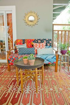 a living room filled with furniture and a sunburst on the wall above it