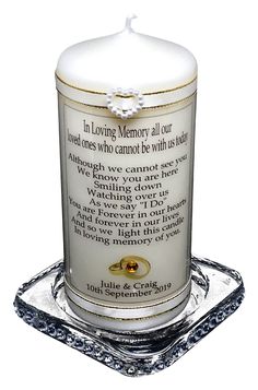 a white candle with a poem on it sitting on a glass stand in front of a white background