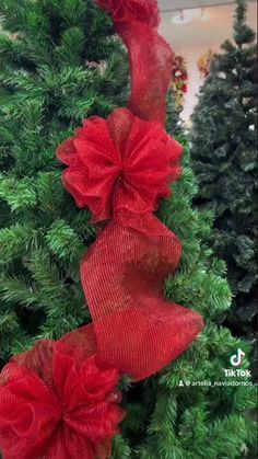 two red bows on top of a christmas tree