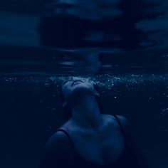 a woman floating in the water with her eyes closed