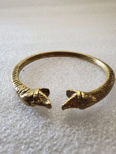 This listing is for an Antique Brass Bangle made in India with double snake heads. It fits comfortably on your wrist and is solid brass, so it is heavy. The engravings are very detailed on both sides of the bangle. There is no marking but on future research I learned they are made in India and are very old. It's very exotic and unique I would stack the bracelet with colored beaded bracelets. I purchased this at an estate sale last summer. It will arrive in a gift box with FREE SHIPPING. Fits up Metal Bracelets With Antique Finish For Ceremonial Occasions, Ceremonial Metal Bracelets With Antique Finish, Antique Brass Bracelets For Ceremonial Occasions, Antique Brass Ceremonial Bracelets, Antique Finish Brass Bracelet In Gold, Antique Finish Gold Brass Bracelet, Antique Finish Brass Gold Bracelet, Gold Antique Finish Brass Bracelet, Ceremonial Bronze Metal Bracelets