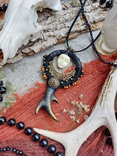 an antler's head is surrounded by beads and other animal skull parts on a rug