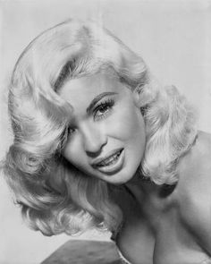 an old black and white photo of a woman with blonde hair wearing a halter top