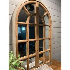 an arched wooden window on the side of a house