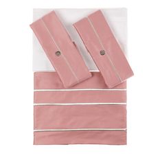 the pink and white bedding is neatly folded on top of each other, with two matching pillow cases