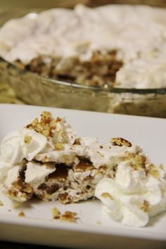 there is a piece of cake on the plate with whipped cream and walnuts around it