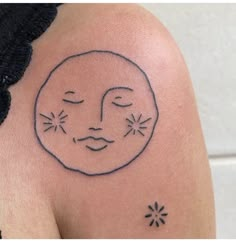 a woman's arm with a sun and stars tattoo on her left side shoulder