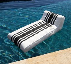 an inflatable lounge chair is floating in the blue water near a swimming pool