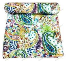 the colorful paisley print fabric is folded on top of an open book cover with a white background