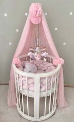 a baby crib with pink and white decor