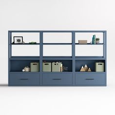 a blue bookcase with books and other items on it's shelves in front of a white wall