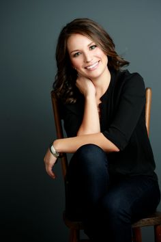 a woman sitting on top of a wooden chair