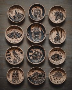 twelve wooden bowls with hand painted designs on them