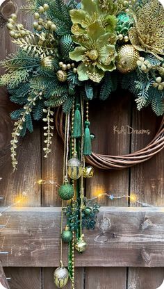 a wreath is hanging on the side of a wooden fence with lights and greenery