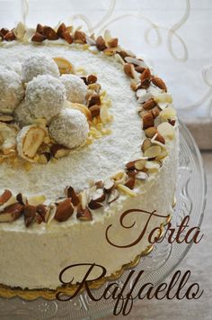 a cake with nuts and powdered sugar on top is sitting on a glass platter