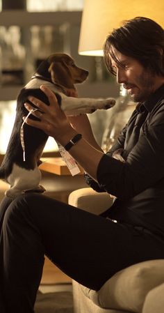 a man sitting in a chair holding a dog