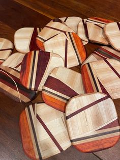 several pieces of wood sitting on top of a wooden floor covered in strips of paint