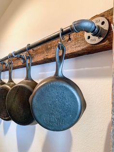 pots and pans are hanging on the wall in front of a coat rack with hooks