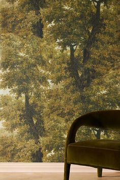 a chair sitting in front of a wall with trees on it