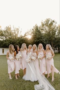 a group of women standing next to each other on top of a lush green field