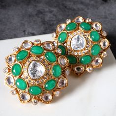 Type: Studs Earring Closure Type: Push Back with German Clip Total Weight: 18 Grams (combined) Approx. Dimensions: 33 mm x 33 mm (end to end) Finish: Matte Gold Elements include: Hand cut glass work (Polki/Kundan) AAAAA Cubic Zirconia Natural Stones - treated - dyed or heated Colour Palette: Green Please note: All the pieces in store are BRASS AND COPPER based No lead or nickel or zinc. Care trips: Store in airtight bags (provided) Like all jewellery it should be the last thing you put on and the first thing you take off Handle gently yet firm hands Colour Palette Green, Palette Green, Snowflake Ring, Shell Ring, Glass Work, Floral Earrings, Matte Gold, Gold Bangles, Stone Earrings