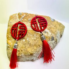 "Asian inspired red tassel earrings depicting a Chinese character \"good fortune\" pronounced Fú. Earrings are cut from 3mm red iridescent acrylic. These statement earrings are perfect for a special night out on the town. Earrings measured 3.75 inches long and 1.25 inches wide. They can be fitted with pierced or clip-on hardwares. Earrings will be placed in a gift box, carefully packed and shipped, perfect as a gift for yourself or a loved one. Any questions? Please feel free to contact me! See Traditional Red Jewelry With Tassels, Red Tasseled Jewelry As A Gift, Red Tasseled Jewelry For Gift, Red Dangle Tassel Earrings As Gift, Red Dangle Tassel Earrings For Gift, Red Tassel Earrings For Gift, Red Bohemian Tassel Earrings As Gift, Festival Gift Jewelry With Tassels, Red Tassel Drop Earrings Gift