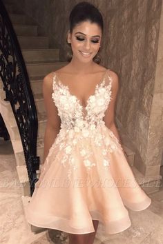 a woman standing in front of stairs wearing a dress with flowers on it