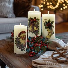 three lit candles on a table with christmas decorations