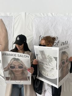 two women holding up pictures of themselves in front of a white backdrop with the words franie salon on them