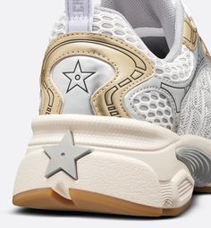 The Dior Vibe sneaker reimagines the classic running shoe with the House's couture spirit. White mesh printed with the Dior Oblique motif is combined with gold- and silver-tone laminated leather-effect panels for a modern play on contrasts. The design is further punctuated with hallmark accents like 3D-effect detailing, a lucky star symbol on the back and signatures on the tongue and rear tab. Completed by an ultralightweight sole adorned with a gray star, the sneaker will complement any casual Star Symbol, Dior Oblique, Short Denim, Luxury Sneakers, Lucky Star, White Mesh, Running Shoe, Sneakers White, Gold And Silver