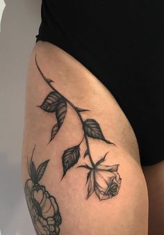 a woman's thigh with flowers and leaves on it