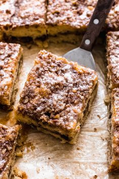 several pieces of cake sitting on top of a piece of parchment paper with a spatula