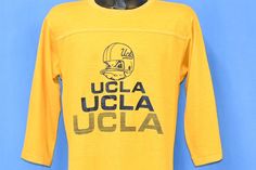 Chest 20 in.  Length 25.5 in.   Tag Says: Artex, M, 100% Cotton, Made in USA  This vintage jersey stye tee supports the UCLA Bruins football team, and features the school's mascot Joe Bruin. This shirt was made in the 70s, back when the football team was still playing their home games at the Los Angeles Coliseum.   Comments: Fits like a modern unisex adult oversized medium, repair on the front and sleeve and hole on the back, see pics           24-08-128327 Graphic Print Jersey For Fan Apparel, Sports Fan Cotton Jersey With Team Logo, Short Sleeve Jersey With Graphic Print For Fans, Graphic Print Short Sleeve Jersey For Fan Gear, Team-colored Graphic Print Jersey For Game Day, Cotton Team Jersey Fan Apparel, Sports Fan Cotton Jersey With Letter Print, Cotton Fan Apparel Jersey With Team Name, Collegiate Cotton Jersey For Fans