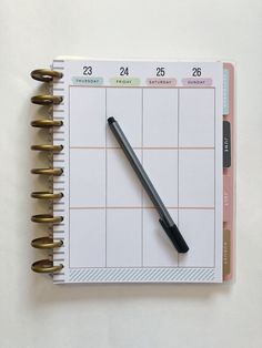 a planner with a pen on top of it next to a spiral bound notepad