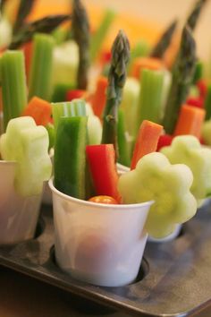 small cups filled with vegetables sitting on top of a metal tray