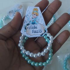 a hand holding a bracelet with pearls and a tag that says bijel fazzi5