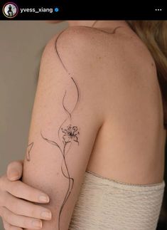 a woman's arm with a flower tattoo on the left side of her arm