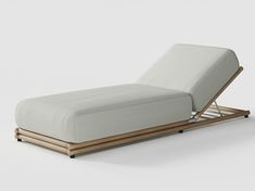 a white chaise lounger with wooden legs and an upholstered back rest