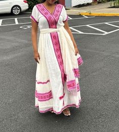 Simple Ethiopian dress with a beautiful trim and  embroidery. This dress comes with full netela (two panel 2m scarf). Model is wearing a M but It can be custome made in any size. please send your size with your order and your phone number. phone numbers are required on the shipping form. Traditional White V-neck Dress, Traditional White Summer Gown, Fitted Short Sleeve Dresses For Traditional Ceremonies, Bohemian Floor-length Dress With Embroidered Border, White Short Sleeve Dress For Traditional Ceremonies, Fitted Wedding Dress With Embroidered Border, Pink Wedding Dress With Embroidered Border, Long Dresses With Floral Embroidery For Traditional Ceremonies, Fitted White Embroidered Dress With Border